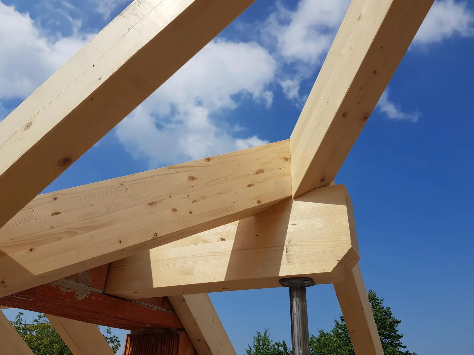 Nahaufnahme einer Holzverbindung, Pfette auf Stütze, gegen blauen Himmel